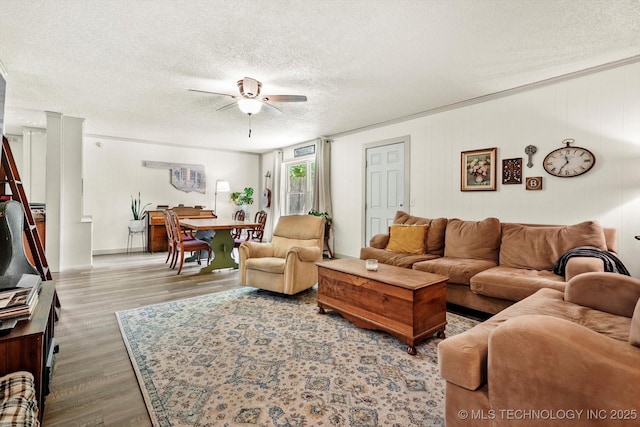 living room featuring a textured ceiling, ceiling fan, and wood finished floors