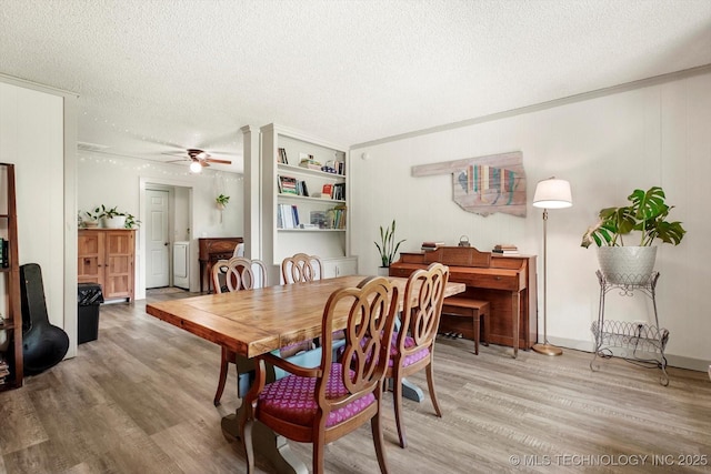 dining space featuring a textured ceiling, ceiling fan, and light wood-style flooring