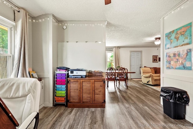 recreation room with a ceiling fan, a textured ceiling, and wood finished floors