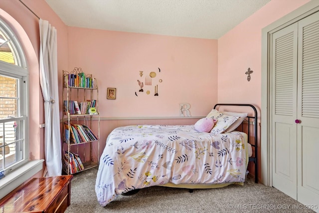 carpeted bedroom featuring multiple windows and a closet