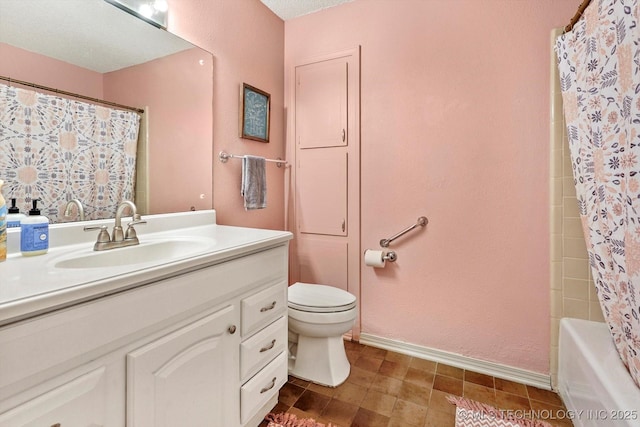 bathroom featuring baseboards, toilet, and vanity