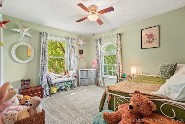 bedroom with carpet flooring, a textured ceiling, and multiple windows