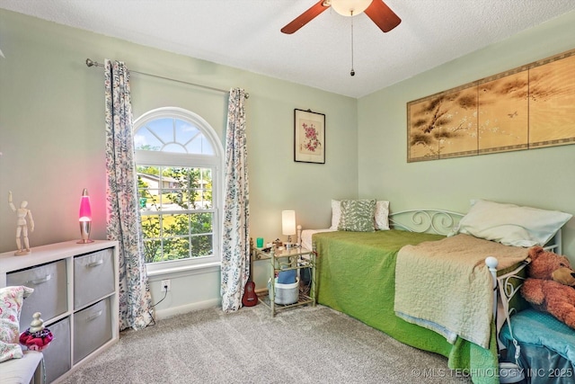 carpeted bedroom with a ceiling fan, baseboards, and multiple windows