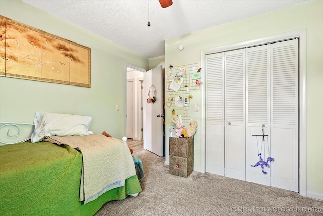bedroom with carpet floors, a textured ceiling, ceiling fan, and a closet