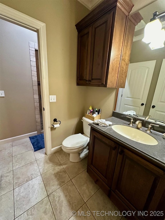 bathroom with toilet, baseboards, tile patterned flooring, and vanity