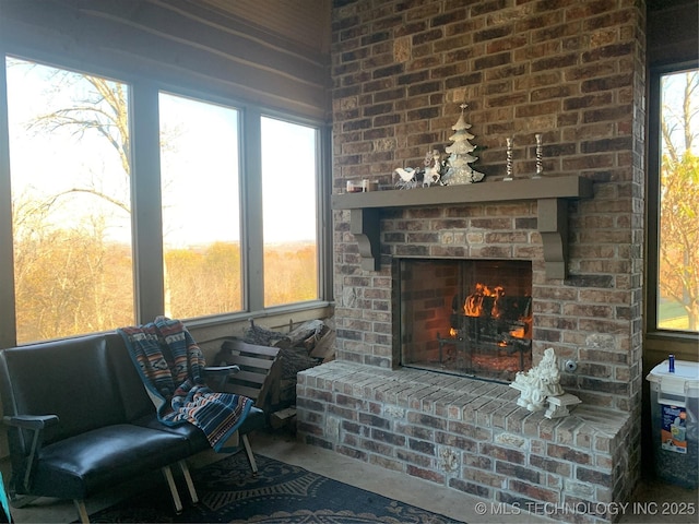 sitting room featuring a fireplace, concrete floors, and a wealth of natural light