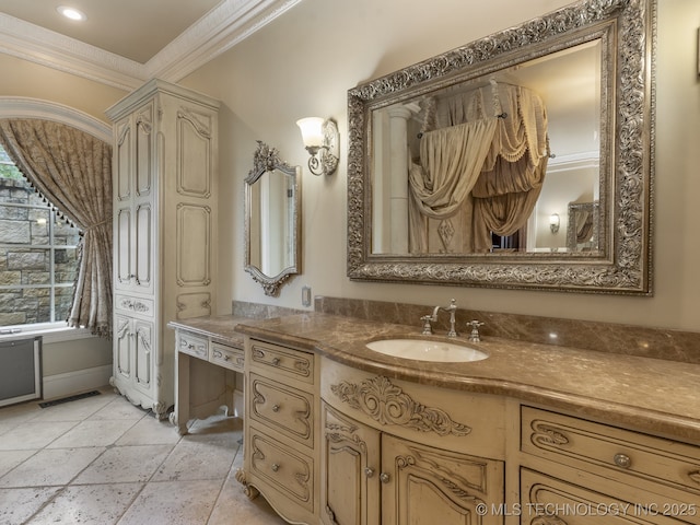 bathroom featuring vanity, stone tile floors, baseboards, visible vents, and ornamental molding