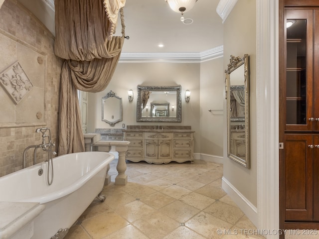bathroom featuring crown molding, baseboards, vanity, and a soaking tub