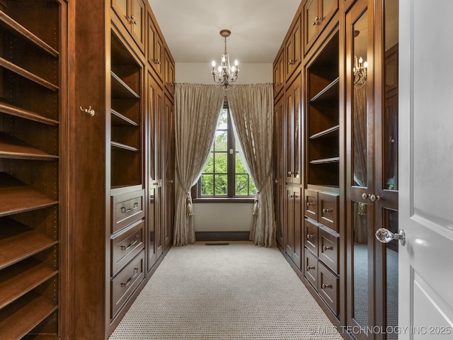 spacious closet featuring an inviting chandelier, visible vents, and light carpet