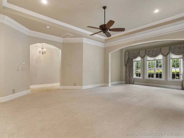 empty room featuring light colored carpet, crown molding, arched walkways, baseboards, and ceiling fan with notable chandelier