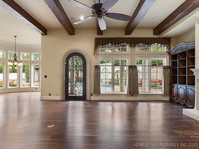 interior space with baseboards, beamed ceiling, ceiling fan with notable chandelier, and wood finished floors