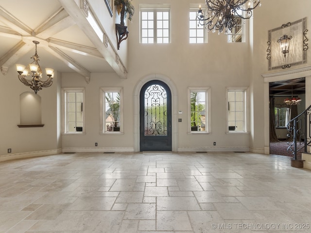 10910 S 69th E Ave, Tulsa, OK 74133 - foyer entrance with a chandelier, stone tile flooring, a towering ceiling, stairway, and beam ceiling