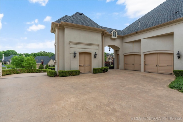 10910 S 69th E Ave, Tulsa, OK 74133 - view of side of home with concrete driveway, stucco siding, a garage, and a high end roof