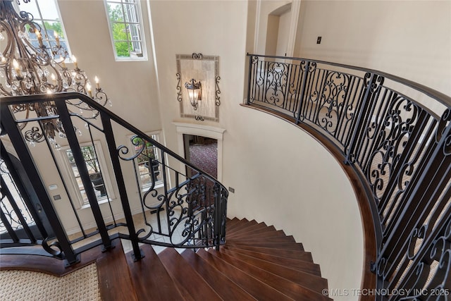 10910 S 69th E Ave, Tulsa, OK 74133 - staircase with a towering ceiling, a chandelier, arched walkways, and wood finished floors