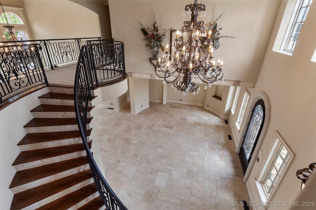 10910 S 69th E Ave, Tulsa, OK 74133 - foyer with a chandelier, stone finish flooring, a towering ceiling, and healthy amount of natural light