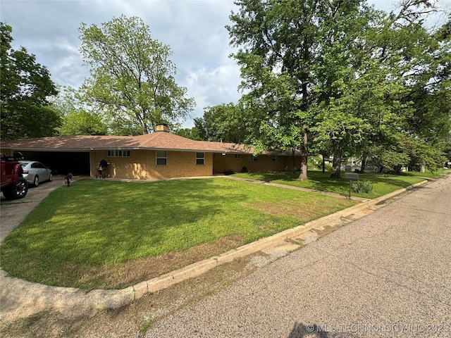 view of home's exterior featuring a garage, a chimney, a lawn, and driveway