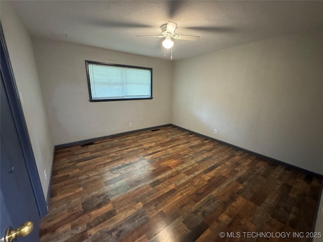 unfurnished room with baseboards, a ceiling fan, and dark wood-style floors