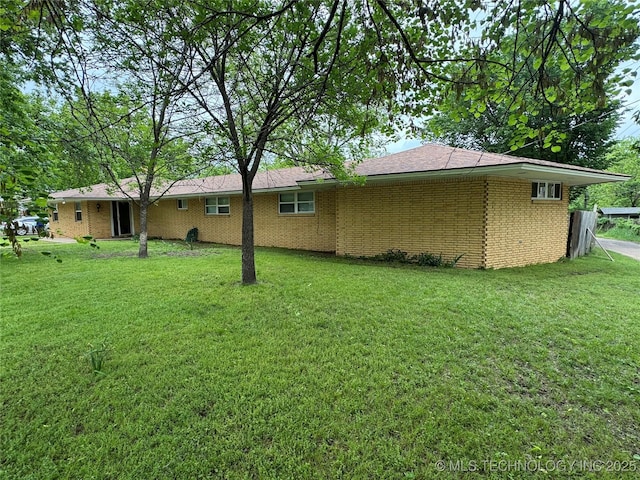 rear view of house with a yard and brick siding