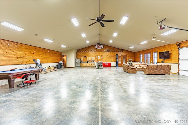garage with ceiling fan, wooden walls, and stainless steel fridge with ice dispenser