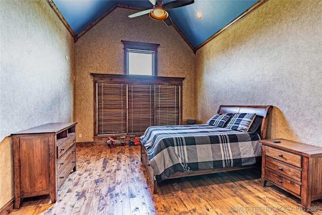 bedroom with crown molding, a ceiling fan, vaulted ceiling, and hardwood / wood-style flooring