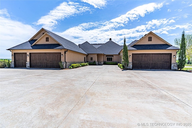 view of front of home featuring concrete driveway, a garage, stone siding, and stucco siding