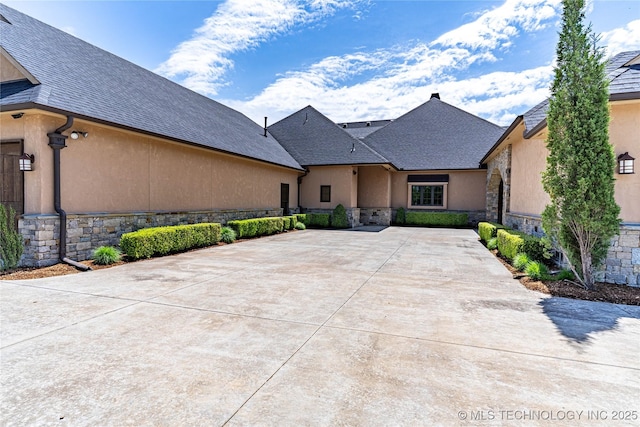 view of front of home featuring stucco siding and stone siding