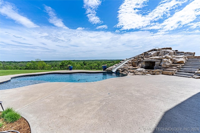 outdoor pool with a patio and a water slide
