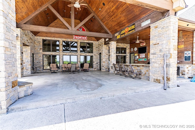 view of exterior entry with ceiling fan and stone siding
