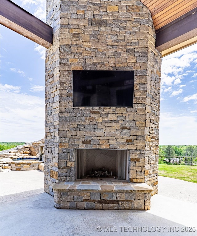 details with an outdoor stone fireplace