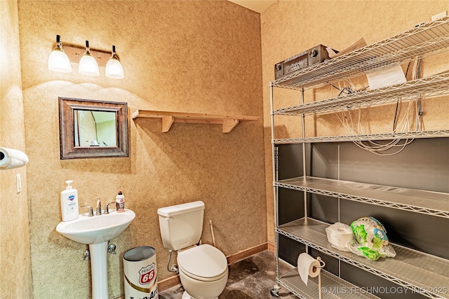 bathroom featuring baseboards and toilet