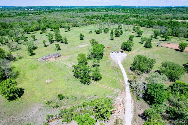 drone / aerial view featuring a view of trees and a rural view