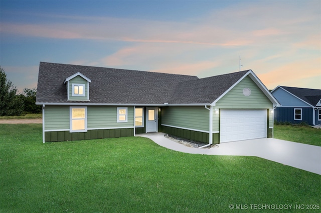 single story home with concrete driveway, roof with shingles, a front yard, and a garage