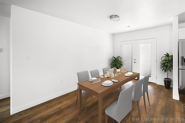 dining space with baseboards and dark wood finished floors