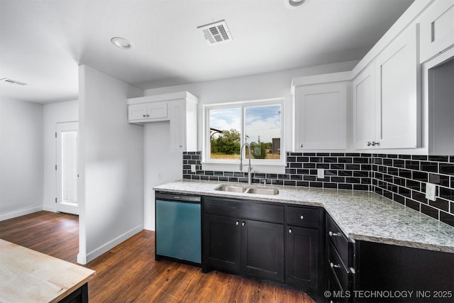 kitchen featuring visible vents, dishwashing machine, white cabinets, dark cabinets, and a sink