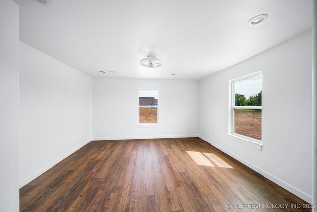 spare room with recessed lighting, baseboards, and dark wood-type flooring