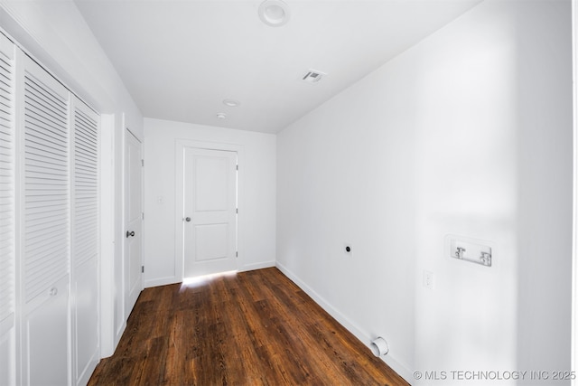 hall featuring baseboards, dark wood-style floors, and visible vents