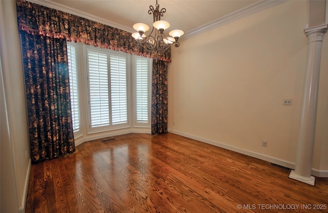 unfurnished room with crown molding, an inviting chandelier, baseboards, wood finished floors, and visible vents