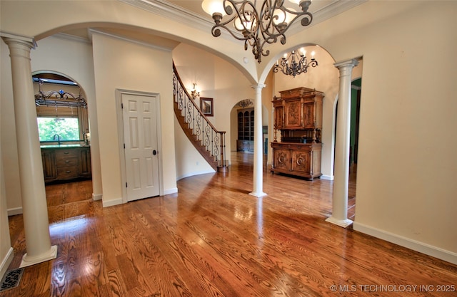 entrance foyer featuring stairs, ornamental molding, and wood finished floors