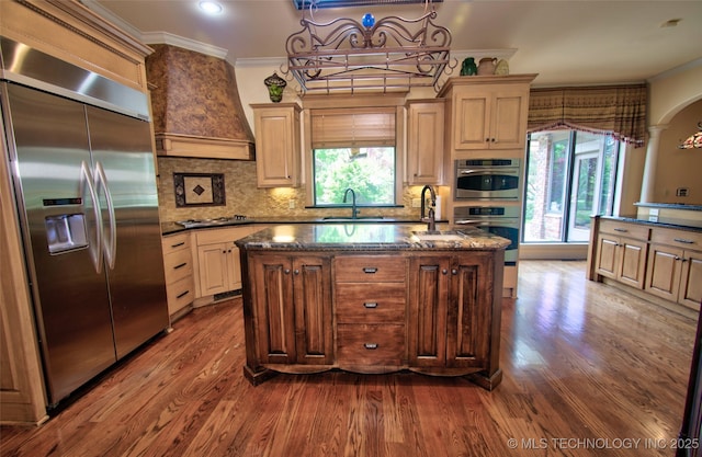 kitchen with crown molding, appliances with stainless steel finishes, tasteful backsplash, a sink, and dark wood-style floors