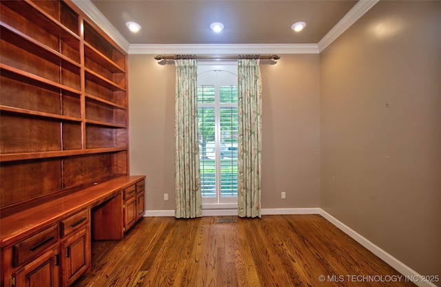 unfurnished office featuring baseboards, ornamental molding, dark wood finished floors, and a wealth of natural light