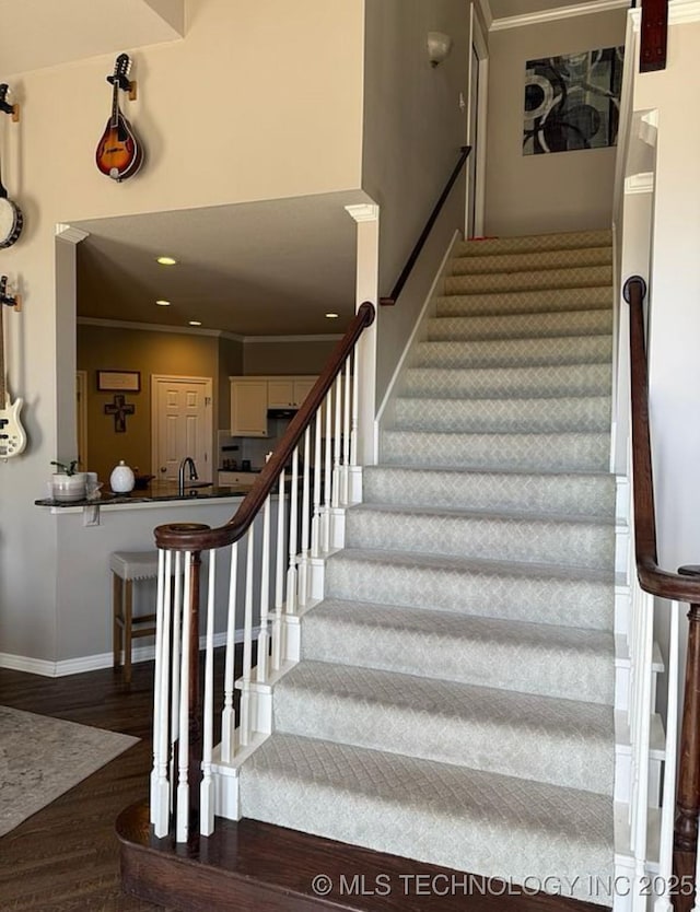 stairs with crown molding, baseboards, recessed lighting, and wood finished floors