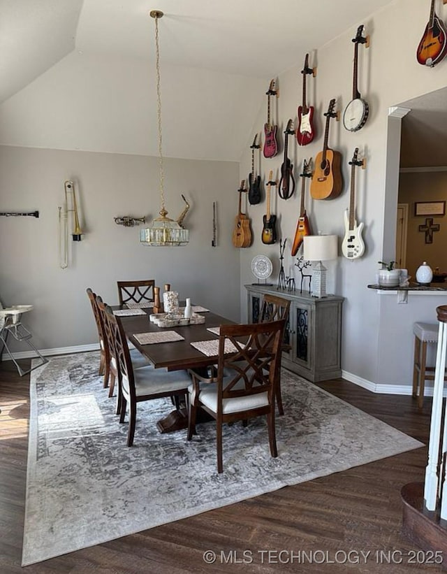 dining room featuring baseboards, wood finished floors, and vaulted ceiling