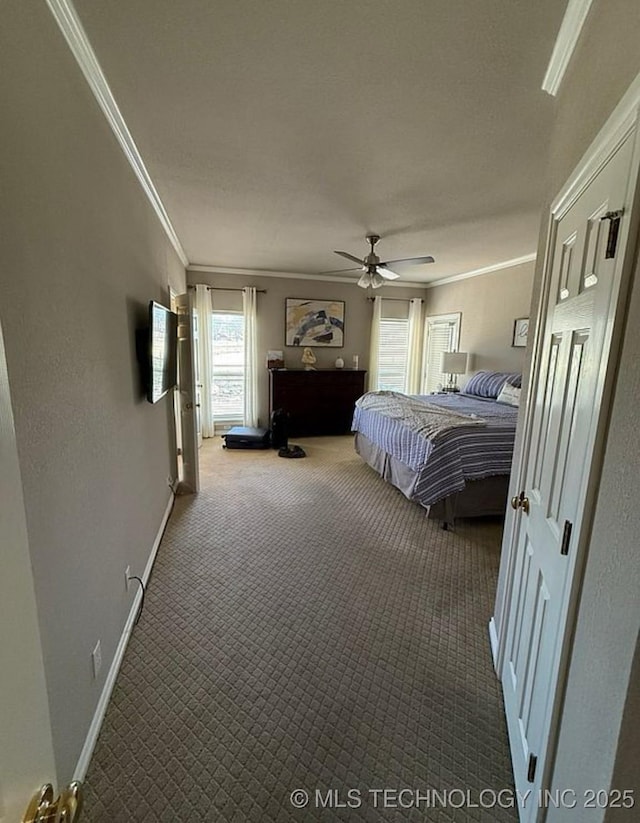 carpeted bedroom with baseboards, ornamental molding, and a ceiling fan