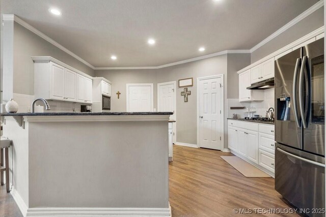 3401 N Narcissus Ave, Broken Arrow, OK 74012 - kitchen featuring stainless steel fridge, under cabinet range hood, white cabinets, recessed lighting, and light wood finished floors