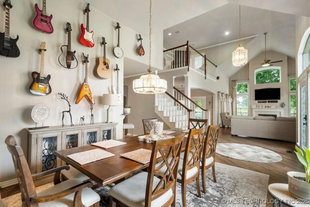 3401 N Narcissus Ave, Broken Arrow, OK 74012 - dining space featuring arched walkways, ceiling fan, stairway, high vaulted ceiling, and wood finished floors