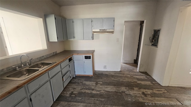 327 N G St, Muskogee, OK 74403 - kitchen featuring gray cabinets, a sink, dark wood-style flooring, and under cabinet range hood