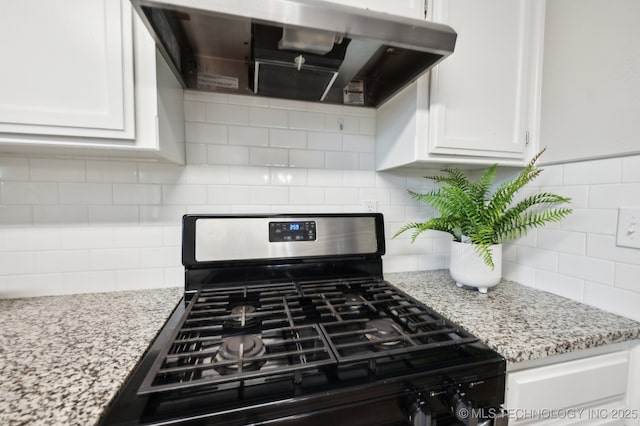 room details featuring stainless steel range with gas stovetop, exhaust hood, tasteful backsplash, and white cabinets
