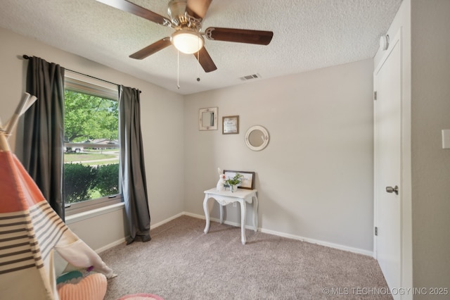 carpeted bedroom with visible vents, a ceiling fan, a textured ceiling, and baseboards