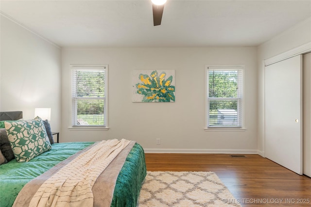 12415 N 75th E Ave, Collinsville, OK 74021 - bedroom featuring wood finished floors, multiple windows, ceiling fan, ornamental molding, and a closet