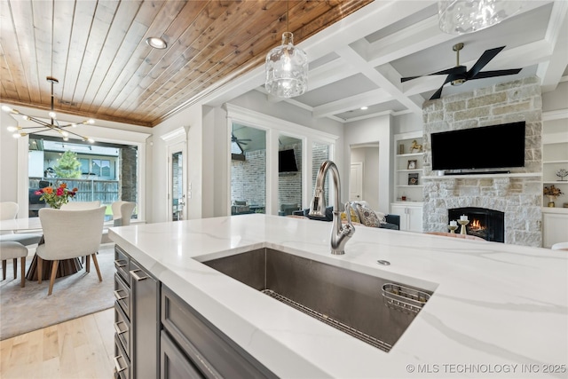 12509 S 102nd E Ave, Bixby, OK 74008 - kitchen featuring decorative light fixtures, a sink, light stone counters, light wood finished floors, and open floor plan